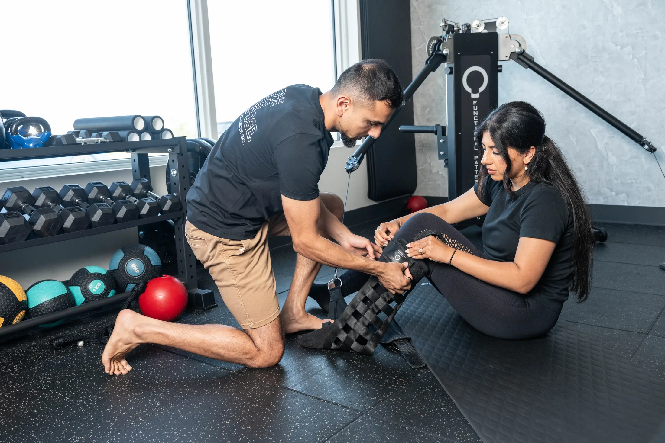 Practitioner fitting a client for a floor exercise